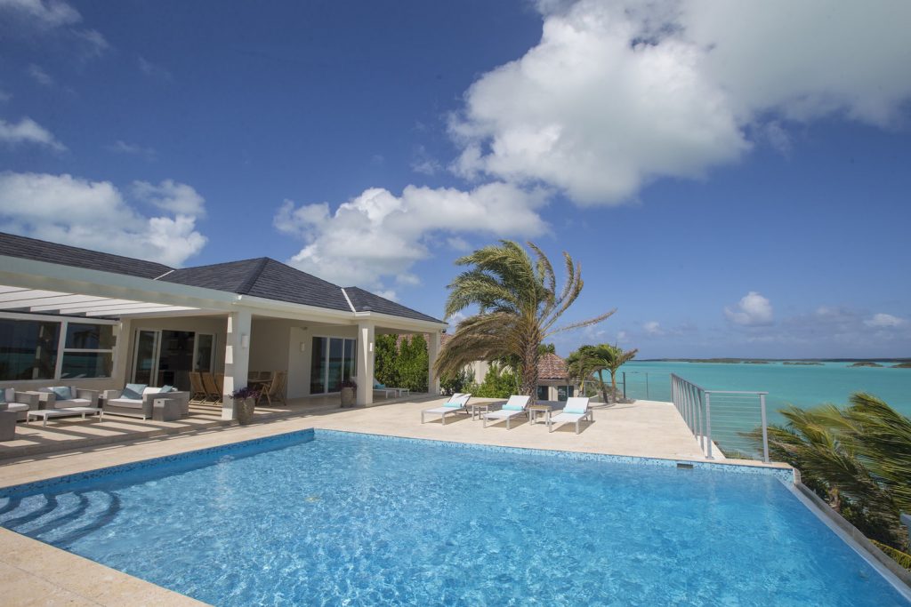 Relaxing pool patio overlooking the ocean with aluminum cable railings