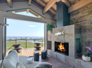 Cozy fireplace room with view to the cable railings and ocean