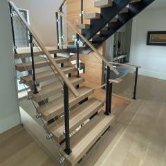 glass-railing-with-sleek-metal-railing-posts-on-double-stringer-stair-keuka-studios